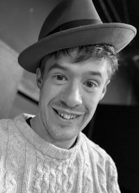 a black and white photo of a man wearing a hat